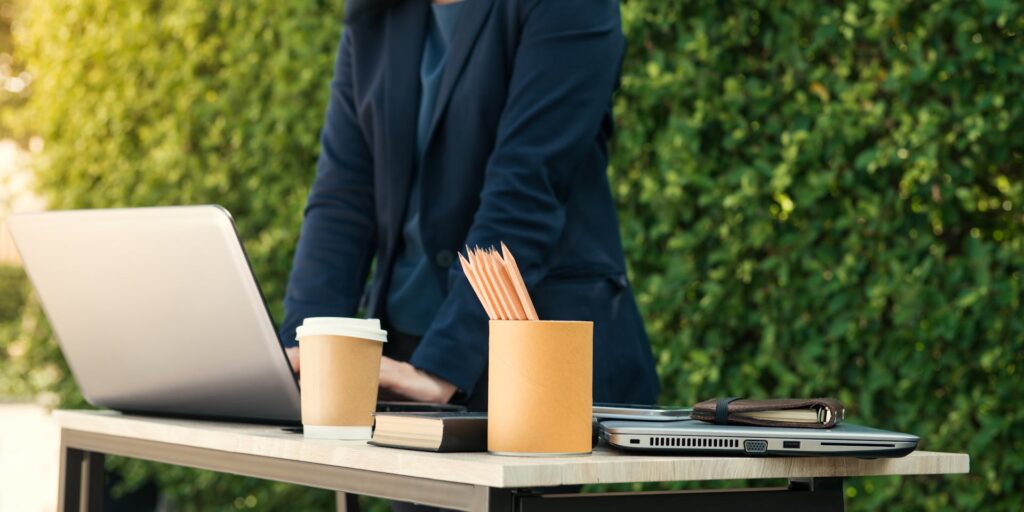 Outdoor office setup with laptop and coffee.