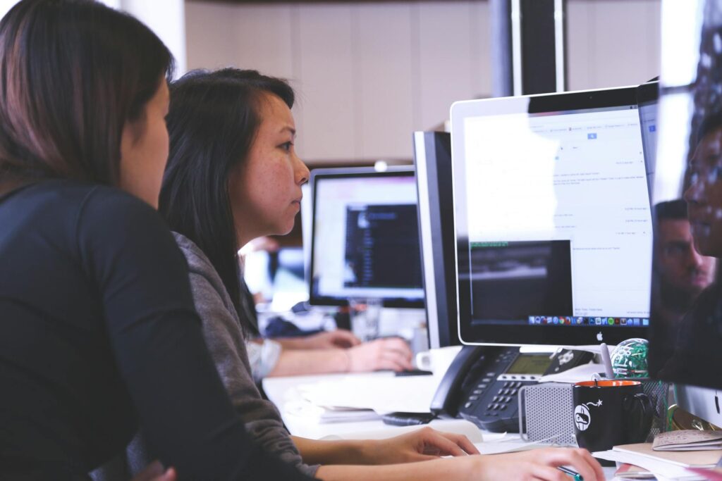 Two professionals working on computer in modern office setting.