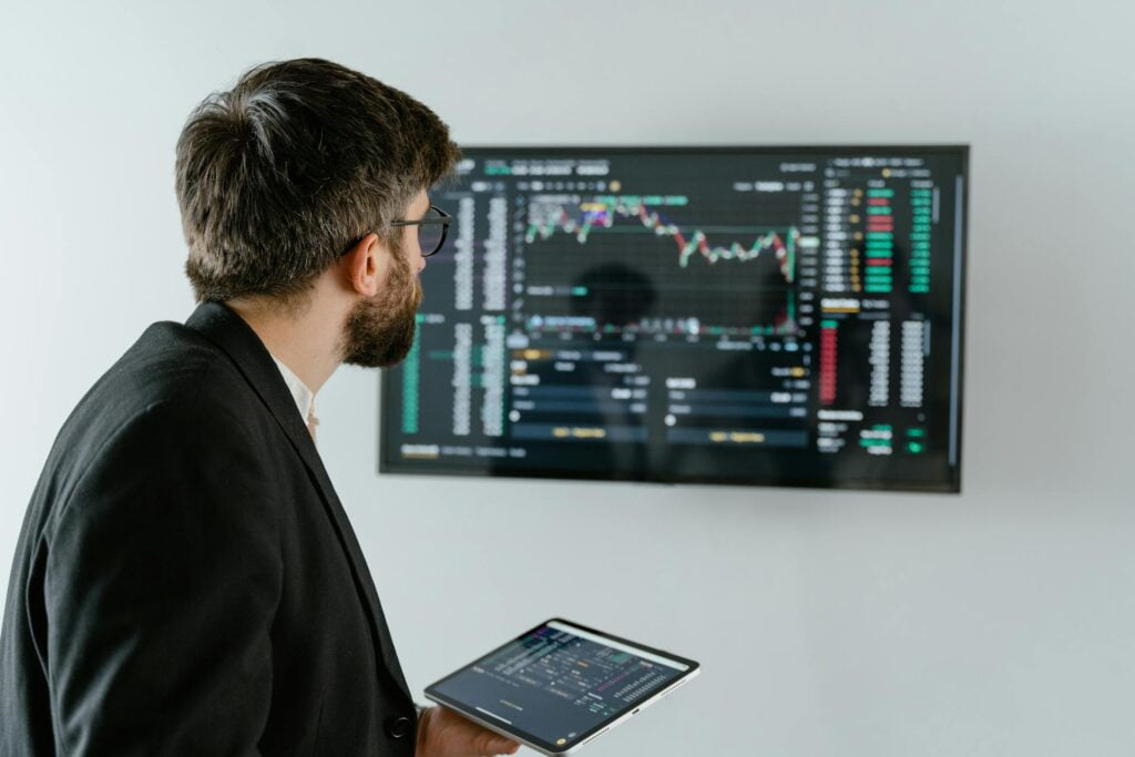 Businessman analyzing stock market data on screens.