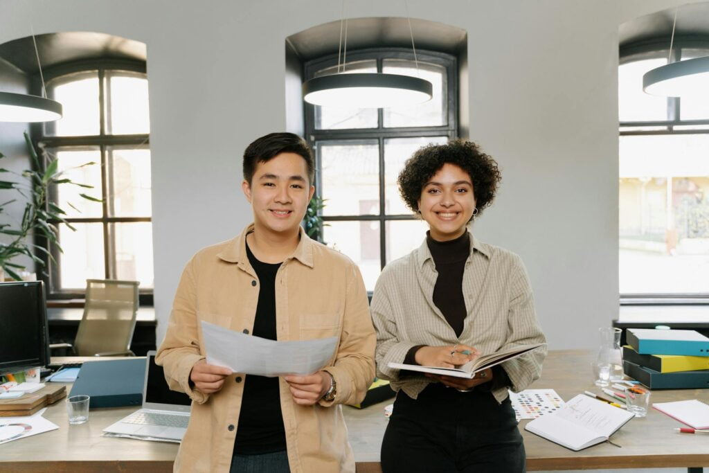 Diverse colleagues smiling with documents in office.