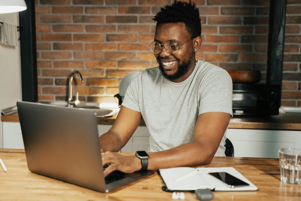 Man working on laptop in modern kitchen setting.