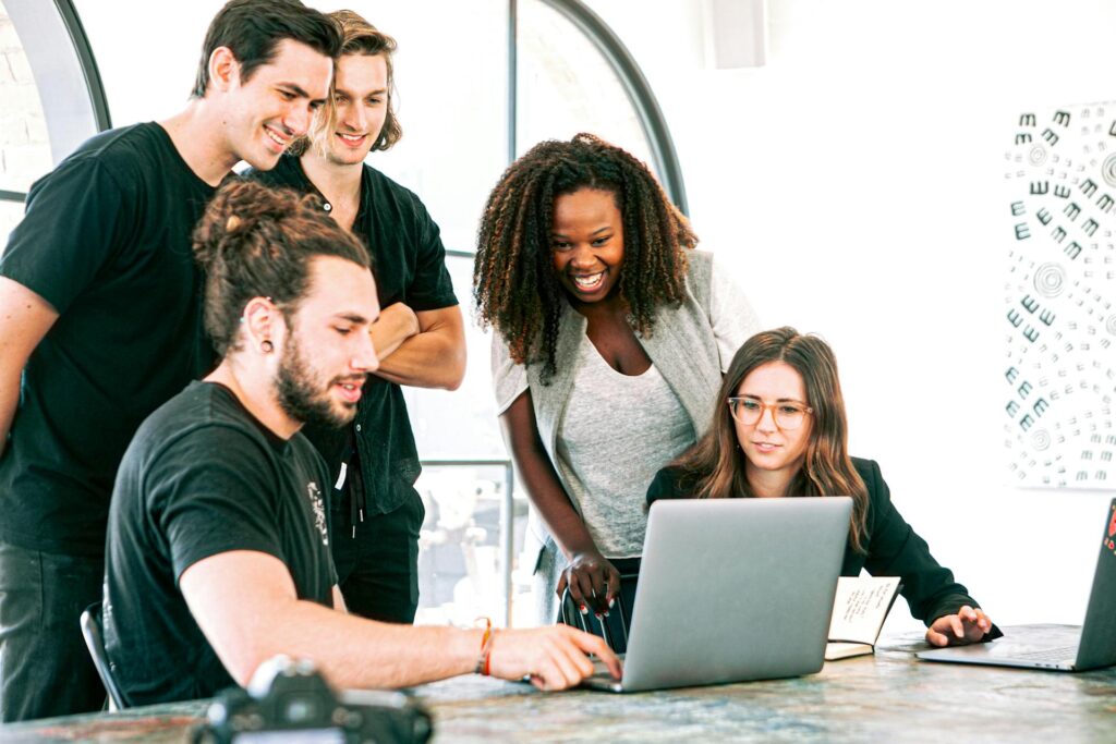 Diverse team collaborating over laptop in bright office.