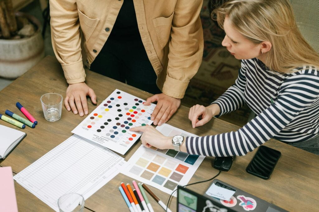 Designers collaborating over color samples on desk.