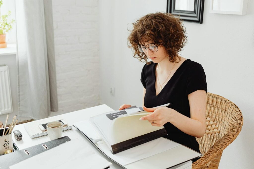 Woman reading at table with coffee.