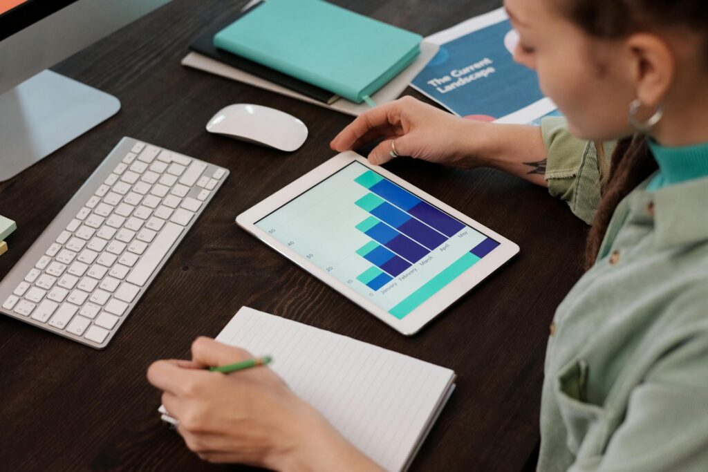 Person analyzing graph on tablet at workplace
