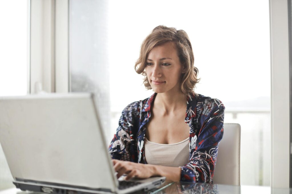 Woman working on laptop in bright office setting