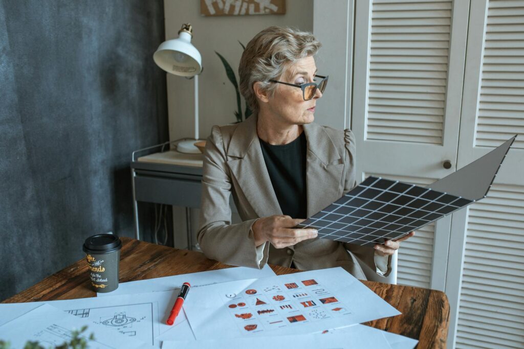 Woman examining material swatch in office setting.