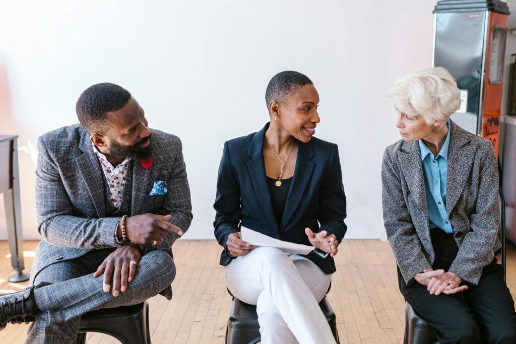 Three professionals discussing in a bright office setting.
