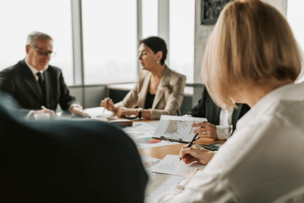 Professionals discussing at business meeting with documents.