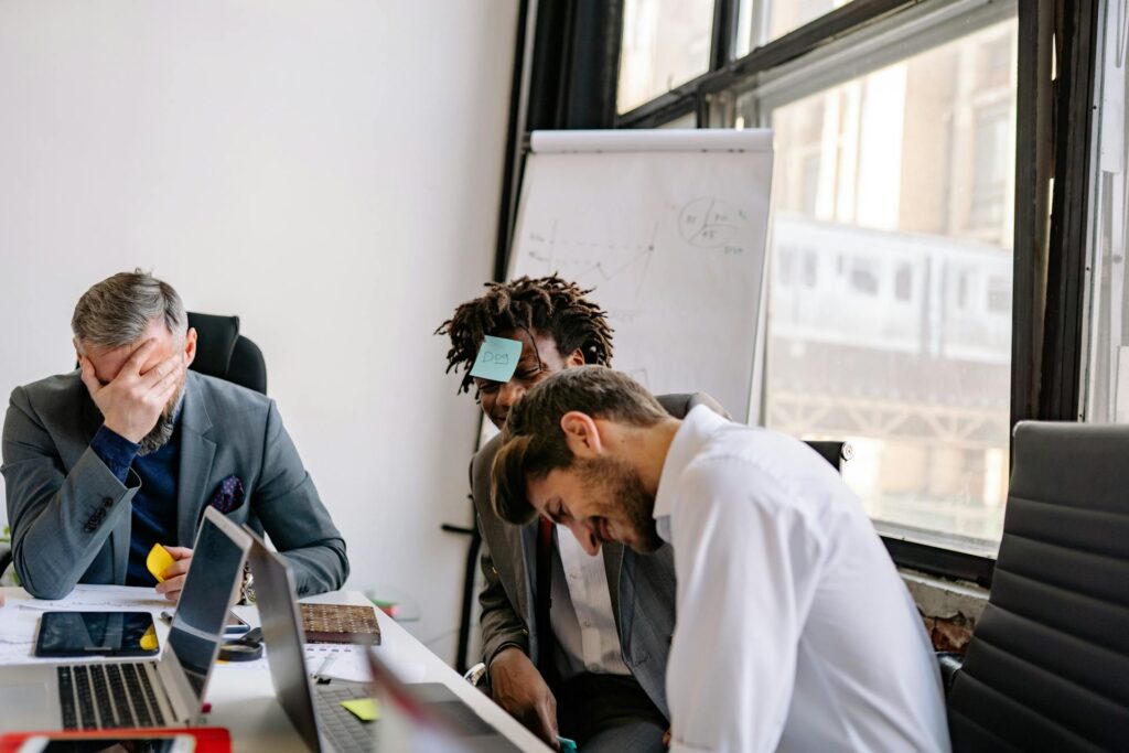 Office workers with sticky notes on foreheads having fun.